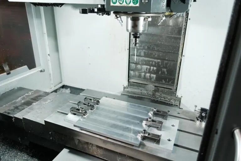 Aluminum plates clamped to the table of a Haas vertical machining center