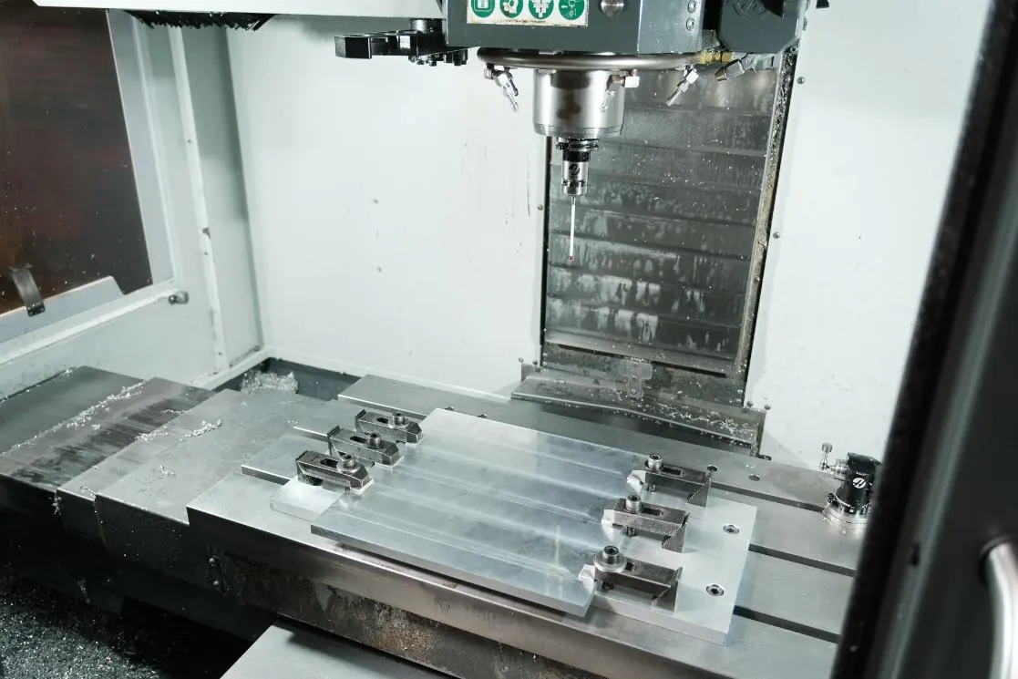 Aluminum plates clamped to the table of a Haas vertical machining center